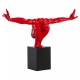 Red resin statue with black marble base, representing an athlete