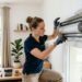 Technicien ouvrant le coffre blanc d'un volet roulant intérieur avec des outils