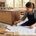 Artisan mesurant et concevant un meuble en bois sur mesure dans un atelier moderne