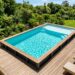 Piscine hors sol avec plage immergée en bois vue du dessus dans jardin verdoyant