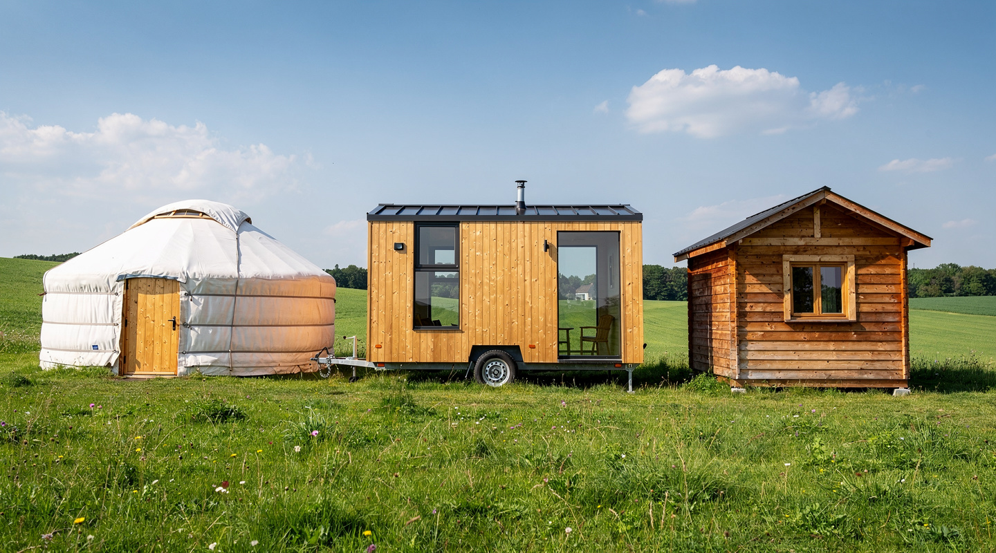 Yourte ronde, tiny house sur roues et cabane en bois côte à côte sur un terrain Yourte ronde, tiny house sur roues et cabane en bois côte à côte sur un terrain