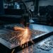 Machine à découpe laser découpant des motifs sur mesure dans une tôle en acier inoxydable