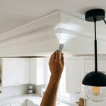 Personne inspectant un angle de plafond de cuisine à la lampe torche