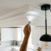 Personne inspectant un angle de plafond de cuisine à la lampe torche