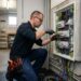 Électricien professionnel intervenant sur un tableau électrique résidentiel
