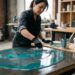 Peintre appliquant un revêtement époxy brillant bleu-gris sur une surface lisse en atelier