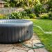 Spa gonflable exterieur relie a un tuyau d arrosage pour la vidange sur une terrasse