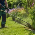 Jardinier utilisant une débroussailleuse avec un fil de coupe neuf le long d'une bordure