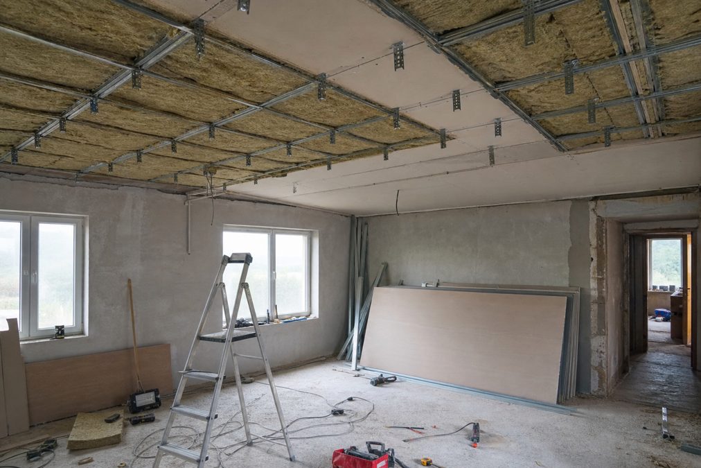 Isolant en laine minérale posé dans le vide d'un plafond acoustique suspendu en cours de chantier