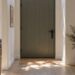 Entrée de maison avec porte moderne surmontée d'une imposte vitrée qui laisse entrer la lumière naturelle