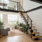 Escalier à pas japonais en bois clair et métal noir menant à une mezzanine dans un loft lumineux