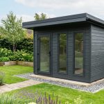 Abri de jardin moderne à toit plat Abri de jardin anthracite à toit plat légèrement incliné posé sur une dalle dans un jardin