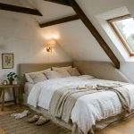 Chambre mansardée avec tête de lit basse Chambre mansardée avec lit double sous la pente et tête de lit basse en tissu beige