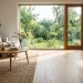 Salon lumineux avec parquet en chêne posé dans le sens de la lumière de la baie vitrée