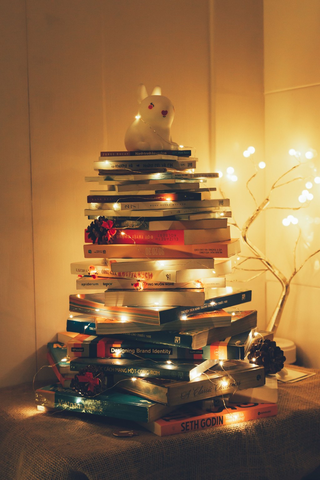 Sapin de livres empilés Sapin de Noël formé d'une pile de livres éclairée par une guirlande lumineuse